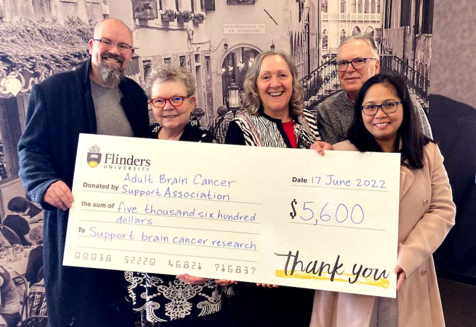 A group of people holding a novelty cheque