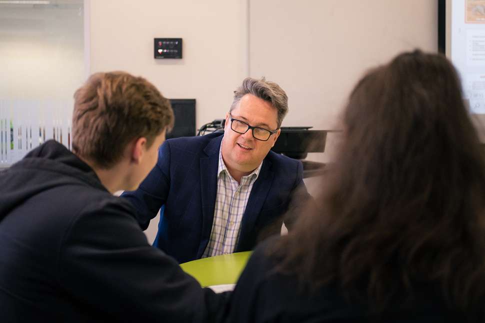Flinders University lecturer engaging with students in a modern classroom setting. 